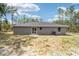 Home's back features a sliding glass door and a large backyard at 117 Nw Sparrow Rd, Dunnellon, FL 34431