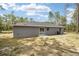 Home's rear view, showcasing a private backyard and sliding glass doors at 117 Nw Sparrow Rd, Dunnellon, FL 34431