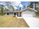 Newly built home with gray exterior, white garage door and a large yard at 117 Nw Sparrow Rd, Dunnellon, FL 34431