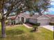 One-story home with a two-car garage, mature trees, and manicured lawn at 12531 Se 90Th Ter, Summerfield, FL 34491