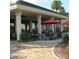 Relaxing patio area with tables, chairs, and red umbrellas at 12531 Se 90Th Ter, Summerfield, FL 34491