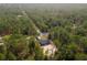 Aerial view of a house in a wooded area with a long road nearby at 1280 Nw Redwood Dr, Dunnellon, FL 34431