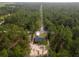 Aerial view of a house in a wooded area with a long road nearby at 1280 Nw Redwood Dr, Dunnellon, FL 34431