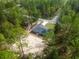 Aerial view of a house in a wooded area with a sandy backyard at 1280 Nw Redwood Dr, Dunnellon, FL 34431