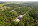 Aerial view of a house nestled in a wooded area with nearby roads at 1280 Nw Redwood Dr, Dunnellon, FL 34431