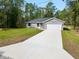 Newly constructed home with a driveway and landscaped yard at 1280 Nw Redwood Dr, Dunnellon, FL 34431