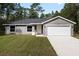 Newly constructed home with a gray exterior, two-car garage, and spacious lawn at 1280 Nw Redwood Dr, Dunnellon, FL 34431