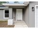 Front entrance with white door and gray siding at 1280 Nw Redwood Dr, Dunnellon, FL 34431