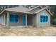 Exterior view of new construction home featuring gray stucco exterior, complemented by light trim, and large windows at 13253 Se 35Th Ct, Belleview, FL 34420