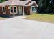 Exterior shot of a home highlighting a concrete driveway leading up to a covered front porch and modern design at 13253 Se 35Th Ct, Belleview, FL 34420