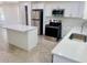 Modern kitchen featuring stainless steel appliances, quartz countertops, and herringbone floors at 13253 Se 35Th Ct, Belleview, FL 34420