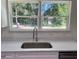 Bright kitchen features white cabinets, quartz countertops and a window with backyard view at 13253 Se 35Th Ct, Belleview, FL 34420