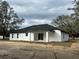 Back view of a white house with black roof and covered patio at 13766 Sw 115Th Pl, Dunnellon, FL 34432