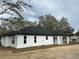 White house with a black roof and covered patio at 13766 Sw 115Th Pl, Dunnellon, FL 34432