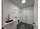 Bright laundry room with utility sink, shelving, and vinyl flooring at 13766 Sw 115Th Pl, Dunnellon, FL 34432