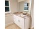 Modern bathroom with white vanity, granite countertop and large mirror at 25 Nw 113Th Cir, Ocala, FL 34482