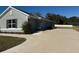 Gray house exterior with large driveway and partial view of fenced backyard at 25 Nw 113Th Cir, Ocala, FL 34482