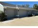 Two-car garage with gray exterior and stone accents at 25 Nw 113Th Cir, Ocala, FL 34482