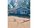 Charming blue home featuring white trim, new roof, and an inviting front entrance surrounded by a sandy lot at 2881 Se 140Th Pl, Summerfield, FL 34491
