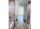 Bathroom featuring a tiled shower, bathtub and vanity and an open view to the living room at 2998 Se 140Th Ln, Summerfield, FL 34491