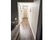 Light-filled hallway with wood-look flooring, leading to bedrooms and bathroom at 3 Maple Run, Ocala, FL 34472