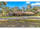 Single-story home with gray siding, brown roof, and a spacious yard at 3650 Se 22Nd Ave, Ocala, FL 34471