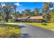 Single story home with a long driveway and lush landscaping at 3650 Se 22Nd Ave, Ocala, FL 34471