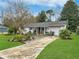 Ranch home with lush landscaping and a long driveway at 3805 Se 138Th Pl, Summerfield, FL 34491