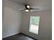 Bright bedroom with a window, ceiling fan, and dark gray vinyl flooring at 5363 Nw 3Rd St, Ocala, FL 34482