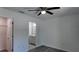 This bedroom features wood-look flooring, a ceiling fan, and a view into an ensuite bathroom at 5363 Nw 3Rd St, Ocala, FL 34482