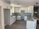Bright kitchen featuring white cabinets, gray countertops, and wood-style flooring at 5411 Nw 7Th Pl, Ocala, FL 34482
