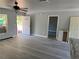 Open floor plan featuring gray wood-look flooring, new white door, window and kitchen island at 5411 Nw 7Th Pl, Ocala, FL 34482