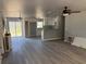 Spacious living room with modern grey flooring open to kitchen with white cabinetry and stone countertops at 5411 Nw 7Th Pl, Ocala, FL 34482