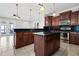 Kitchen with island, dark wood cabinets, and granite countertops at 630 Sw 210Th Ave, Dunnellon, FL 34431