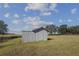 Gray storage shed with wooden fence and expansive grassy yard at 630 Sw 210Th Ave, Dunnellon, FL 34431