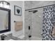 This bathroom boasts marble-look tile, modern fixtures, and a patterned shower curtain at 7646 Sw 129Th Pl, Ocala, FL 34473