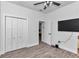 A simple bedroom with wood-look tile floors, a closet, and a wall-mounted television at 7646 Sw 129Th Pl, Ocala, FL 34473