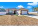 Single-Gathering home featuring a two-car garage, stone accents, manicured lawn, and bright natural light at 7646 Sw 129Th Pl, Ocala, FL 34473