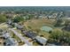 Expansive aerial of homes in a verdant community and natural pond providing a picturesque backdrop for relaxed living at 8822 Sw 108Th St, Ocala, FL 34481