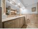 A bathroom featuring a vanity with cabinets, a large mirror, and beige tile throughout at 8822 Sw 108Th St, Ocala, FL 34481