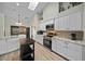 Well-lit kitchen with white cabinets, granite countertops, stainless steel appliances, and wood-look floors at 8822 Sw 108Th St, Ocala, FL 34481