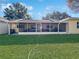 View of home's backyard with grassy lawn and screened porch at 9395 Sw 97Th Ln # B, Ocala, FL 34481