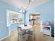 Bright dining area with white table and chairs, view into kitchen at 9395 Sw 97Th Ln # B, Ocala, FL 34481