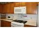 White appliances and wood cabinets in this kitchen at 9662 Sw 97Th Ln, Ocala, FL 34481