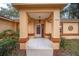 Covered entryway with tiled floor and a wooden door at 10090 Sw 78Th Ct, Ocala, FL 34476