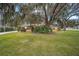 House exterior view with oak trees and a well-maintained lawn at 10090 Sw 78Th Ct, Ocala, FL 34476