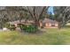 Single-story house with a tree-covered yard and a paved driveway at 10090 Sw 78Th Ct, Ocala, FL 34476