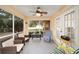 Relaxing screened porch with wicker furniture, ceiling fan, and view of backyard at 10090 Sw 78Th Ct, Ocala, FL 34476