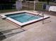 Square hot tub with brick border and safety rail at 10470 Sw 99Th Ave, Ocala, FL 34481