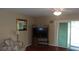 Living room featuring a floral armchair, TV stand, and sliding glass door at 10470 Sw 99Th Ave, Ocala, FL 34481